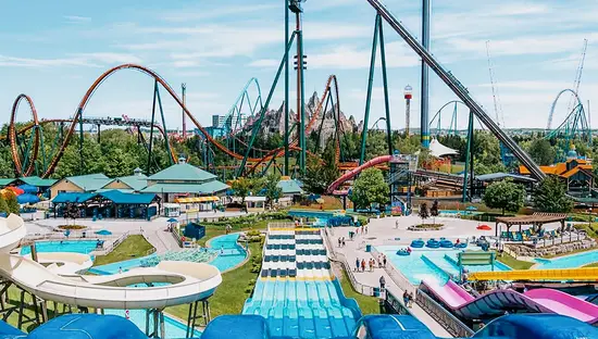 Parc d’attractions animé avec des glissades d’eau, des montagnes russes et une tour sous un ciel ensoleillé à Canada’s Wonderland, à Vaughan.