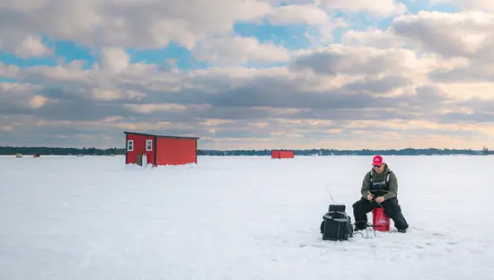 A man ice fishing on Lake Nipissing.