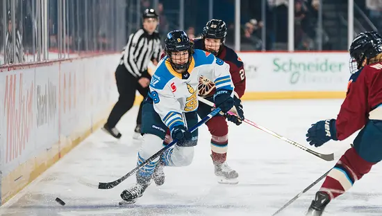 Joueuse des Sceptres de Toronto affrontant deux femmes de l’équipe adverse dans un match de hockey.