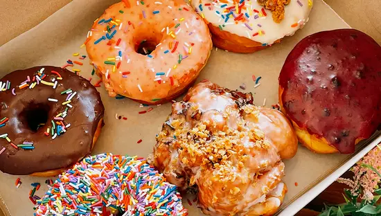 An assortment of colourful doughnuts in a box.