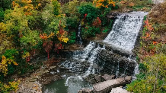 Overhead photo capturing a waterfall surrounded by fall colours.
