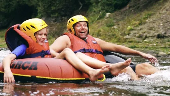 Ein Erwachsener und ein Kind haben im Sommer Spaß beim River-Tubing.