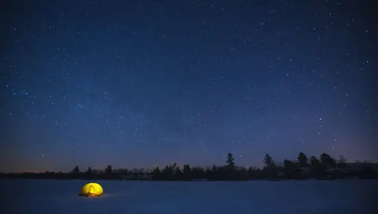 夜、星空の下で光るテント。