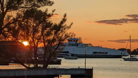 Un navire sur l’eau au coucher du soleil.