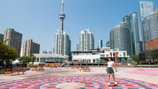 ハーバーフロントセンターの前のカラフルな歩道でスケートボードをする人。