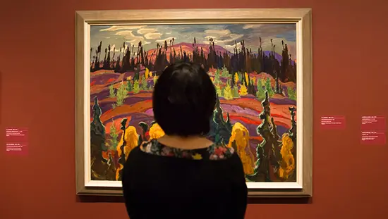 한 여성이 Group of Seven 그림 앞에 서 있습니다.