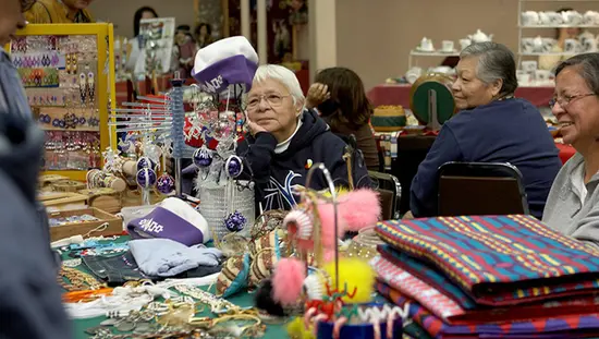 A woman walks by Indigenous art and carvings at Woodland Cultural Centre.