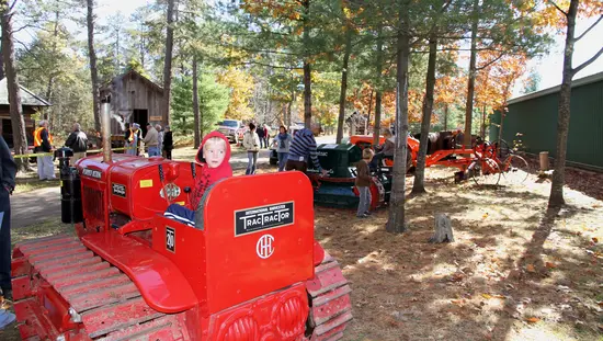 A child sits on top of a tractor on display.