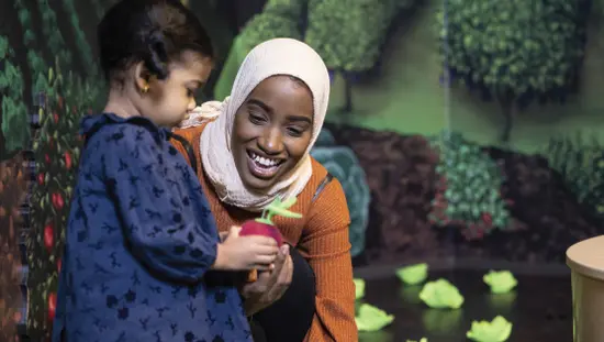 女性におもちゃを見せる子供