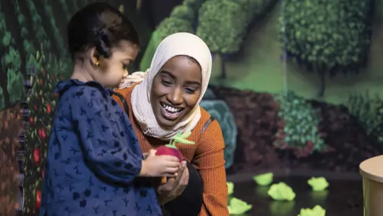 A child showing a toy to a woman