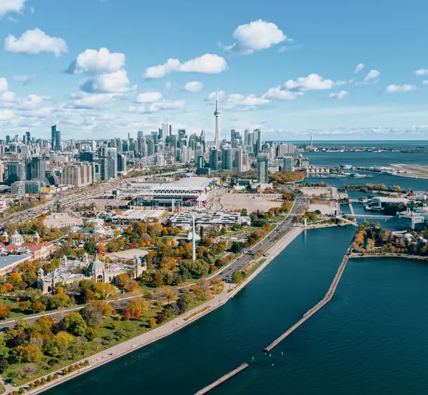 Ontario Place and Exhibition Place seen from above on Toronto’s waterfront, with Lake Ontario and the skyline under blue skies with scattered clouds.