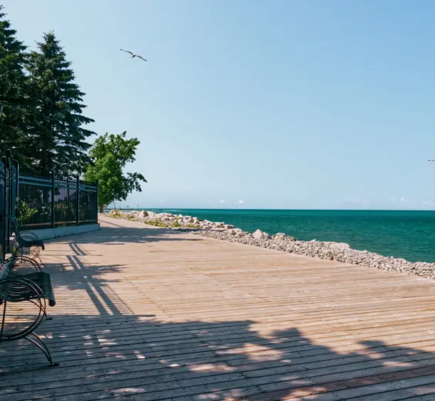 Promenade in Goderich, Ontario, entlang des türkisfarbenen Wassers des Lake Huron unter einem strahlend blauen Himmel.