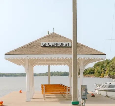 Un quai couvert sur le lac Muskoka, auquel un voilier est amarré, par une belle journée d’été.