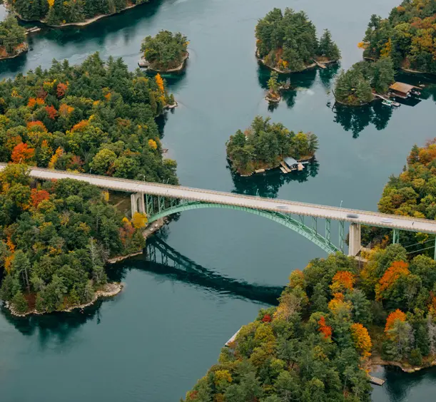 Gananoque et Mille-Îles Le pont des Mille-Îles relie l'Ontario et l'État de New York, surplombant des îles boisées aux couleurs automnales et des eaux calmes.