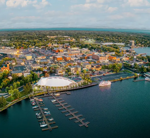Luftaufnahme von Kenora, Ontario bei Sonnenuntergang, mit an der Küste angedockten Booten und sanften violetten Wolken über dem Lake of the Woods.