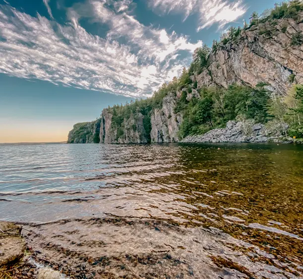 Der majestätische Mazinaw Rock spiegelt sich an einem sonnigen Tag im See des Bon Echo Provincial Parks.
