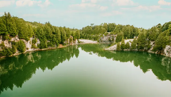 Une vue scénique d’Elora montrant une carrière tranquille bordée de falaises abruptes et d’une végétation abondante.