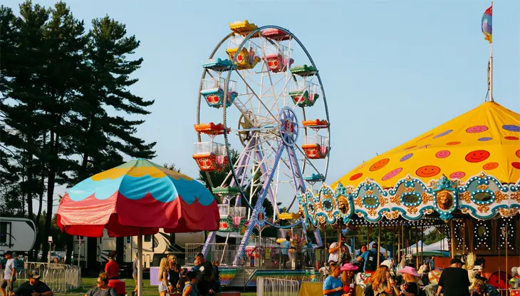 Parc d’attractions animé de Spencerville, avec un carrousel jaune à droite et une grande roue au centre.
