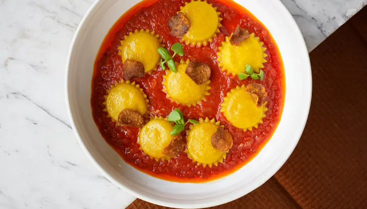 A bowl of vegetarian ravioli in tomato sauce served at Gia, a MICHELIN recognized restaurant in Toronto.