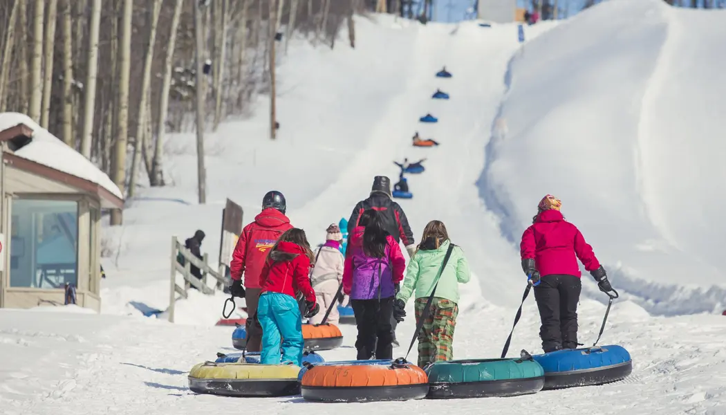 A family pulls inner tubes towards a snow tubing hill at Mount Jamieson in Timmins.