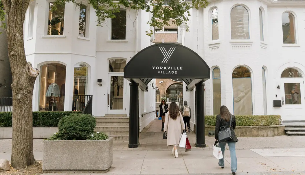 トロントのヨークビルにあるビクトリア朝の建物内のブティック ショッピング センターに買い物客が出入りしている。