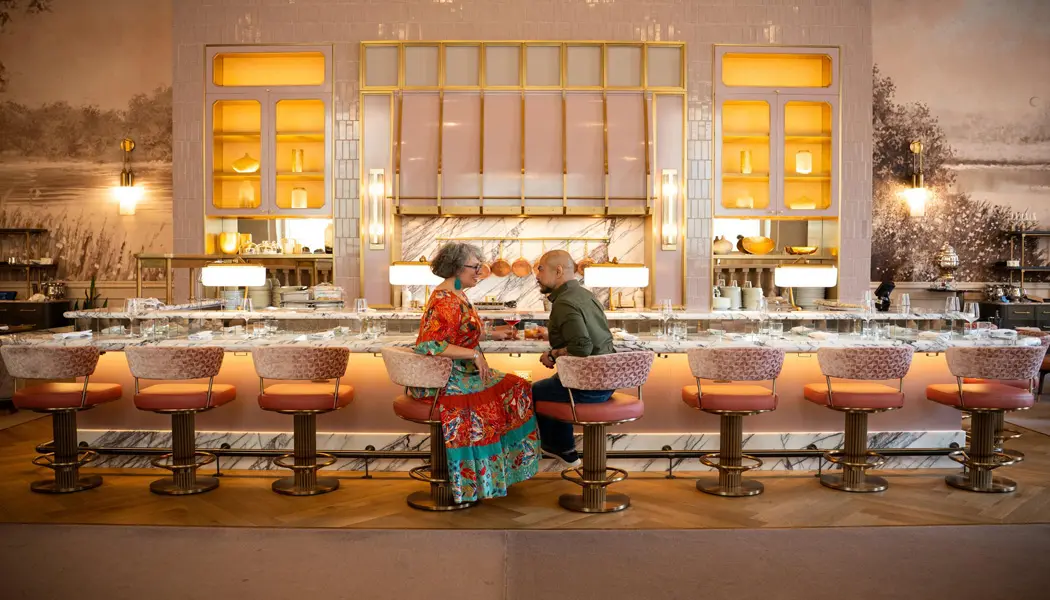 A couple sits on plush barstools at Zoe’s, the stylish, warm and romantic lounge at Ottawa’s iconic Fairmont Château Laurier. 