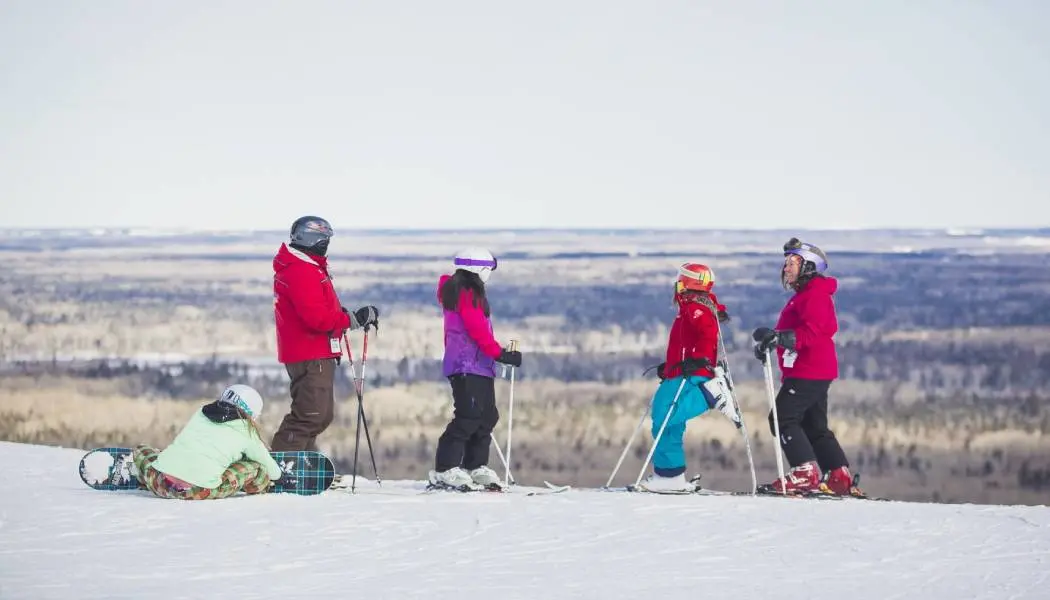 A family of five are ready to downhill ski and snowboard down a snowy hill at Mount Jamieson in Timmins.