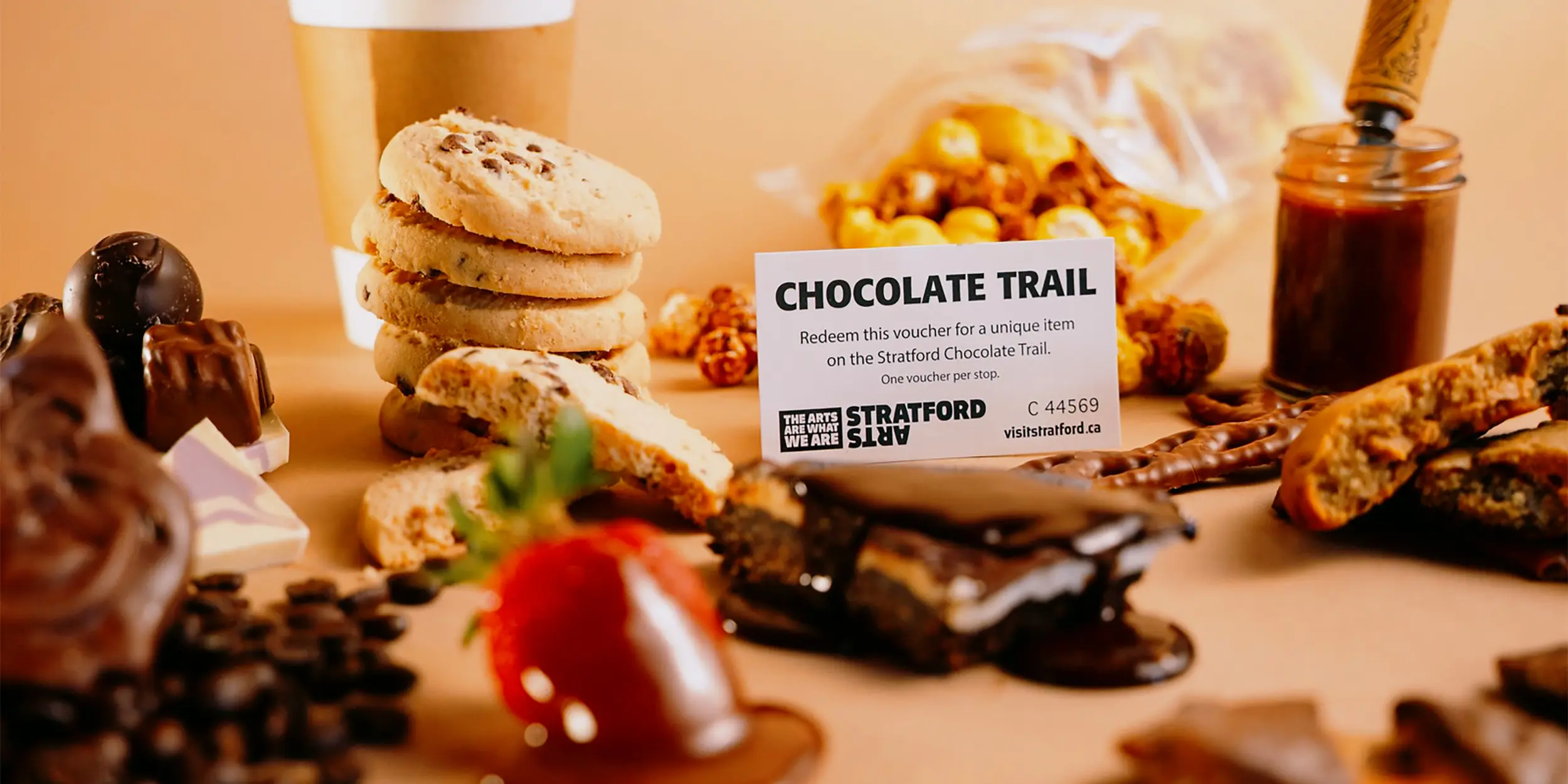 수제 초콜릿과 디저트들이 커피 원두와 코코아 가루와 함께 테이블 위에 보기 좋게 놓여 있습니다.