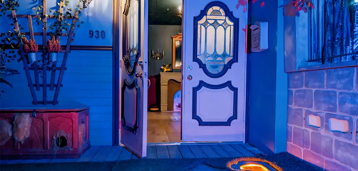 Immersive art installation with glowing floor projections and colourful lighting in a darkened corridor.