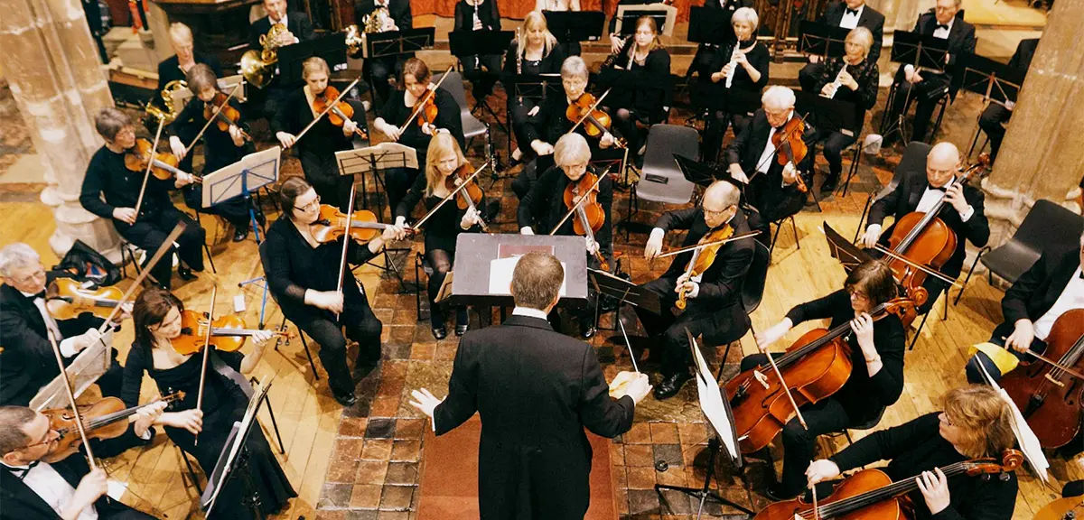 ライブコンサート中に指揮者とともに演奏するオーケストラ。