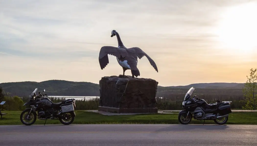 Zwei Motorräder sind zu beiden Seiten der berühmten Gänsestatue mit Blick auf den Lake Superior in Wawa, Ontario, geparkt.