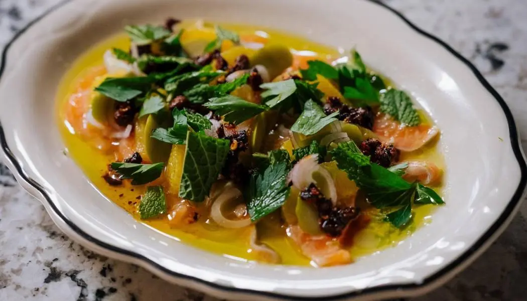 수 세인트 마리의 한 레스토랑에서 채소로 장식된 다채로운 색깔의 수프 한 그릇을 클로즈업한 사진.