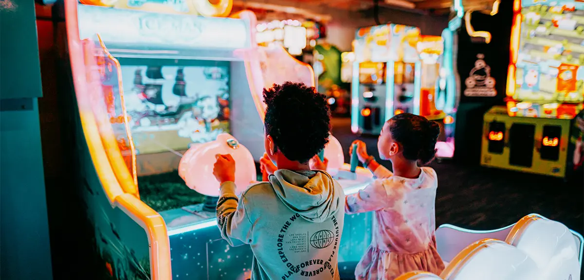 Dos niños pequeños disfrutan jugando a un videojuego en The Factory, en London, Ontario.