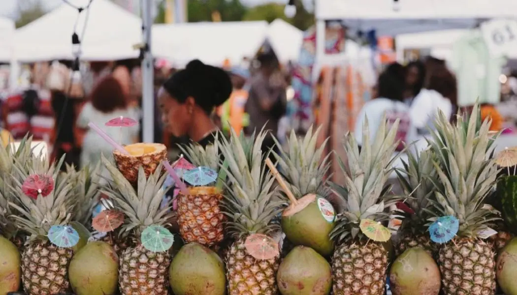 Un étalage de mangues et d'ananas empilés chez un vendeur de nourriture lors d'un festival gastronomique estival à Toronto.