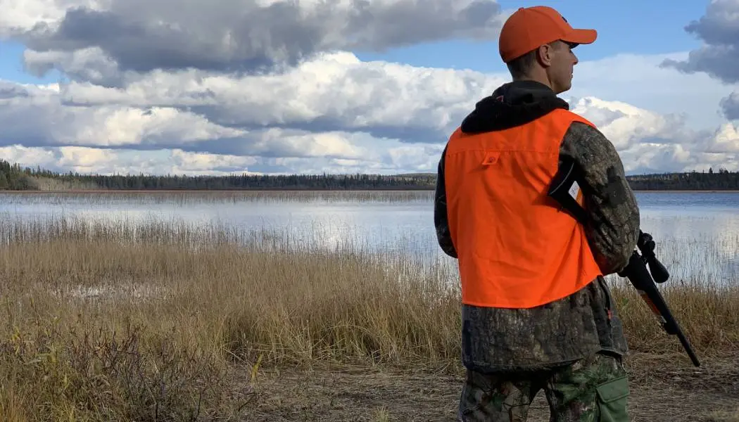 Ein Mann, der auf der Jagd nach Auerhühnern in Algoma Country im Norden Ontarios eine Schusswaffe trägt.