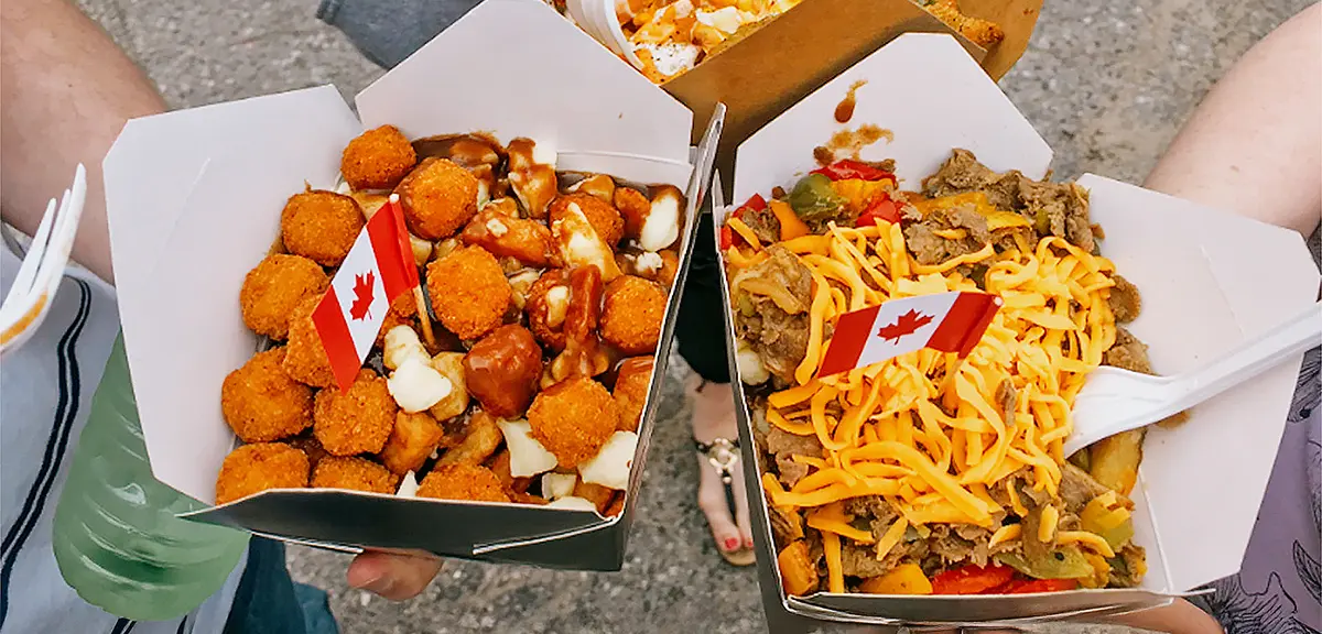 Durante el Poutine Fest en el condado de Algoma, la gente comparte bandejas de poutine cubiertas con queso en cubos, salsa y bocaditos fritos.