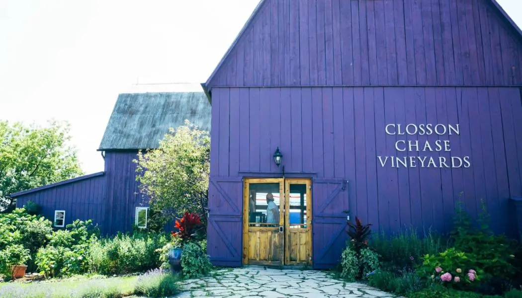 Un gran granero de color lavanda con puertas de madera sirve como sala de degustación de la bodega PEC.