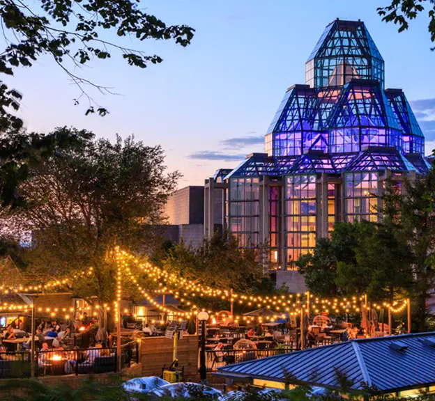 Abends treffen sich Menschen unter funkelnden Lichtern auf einer Außenterrasse in Ottawa. 