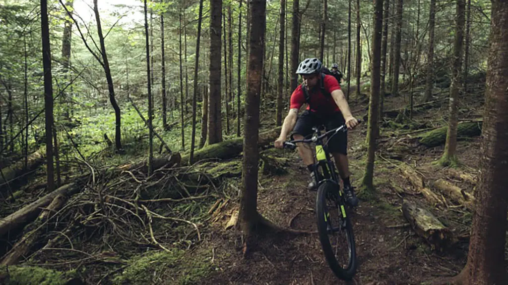 Un homme faisant du VTT sur un sentier forestier accidenté.