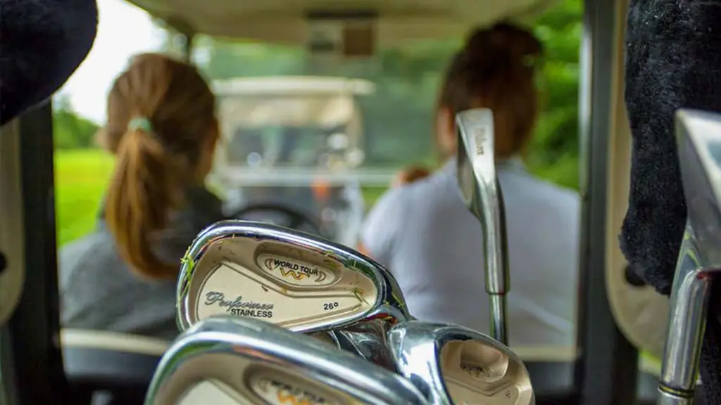 Zwei Frauen fahren mit einem Golfwagen über einen Golfplatz in Ontario.