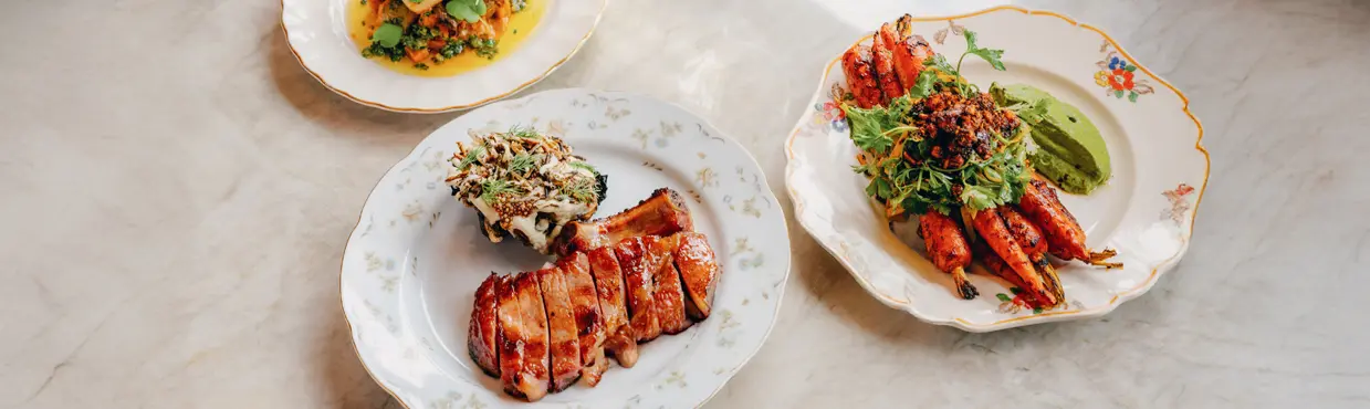 トロントのミシュランガイドレストラン「ザ・ウッド・オウル」では、焼き魚、艶出しポークチョップ、ローストしたニンジン、ワインが提供されます。