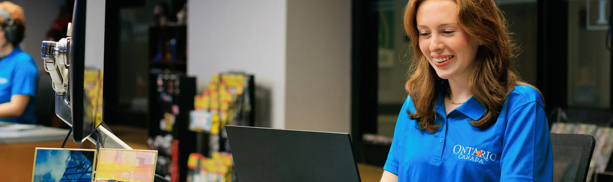 Spécialiste en voyages de Destination Ontario assise devant un ordinateur, aidant un client à planifier son voyage en ligne.