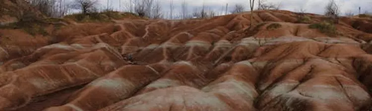 Nahaufnahme eines trockenen, lehmreichen Geländes, das als Badland bekannt ist. 