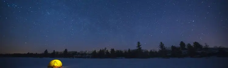 Ein leuchtendes Zelt unter den Sternen in der Nacht.
