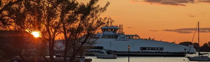 Ein Boot auf dem Wasser bei Sonnenuntergang.