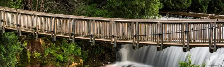 Un pont suspendu au-dessus d’une cascade.