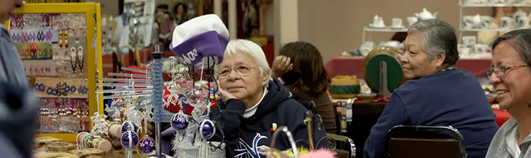 한 여성이 우드랜드 문화 센터에서 원주민 예술품과 조각품 옆을 걷고 있습니다.