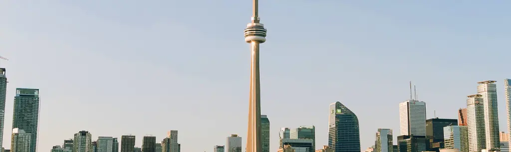 Vue partiellement nuageuse de la silhouette de Toronto depuis les rives du lac, avec notamment la Tour CN et le Rogers Centre.