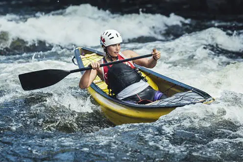 Un canoéiste solitaire navigue dans des rapides d'eau vive