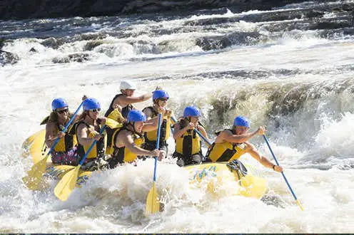 Groupe dans un canot pneumatique sur des rapides d'eau vive
